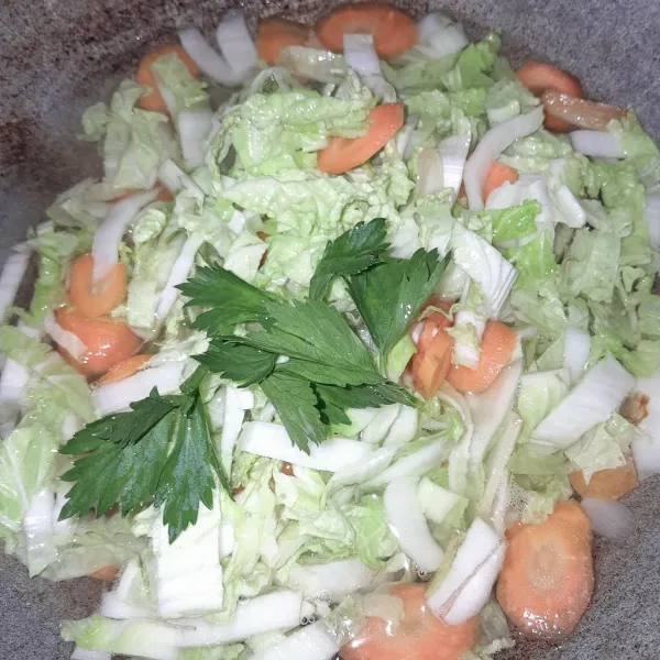 Tambahkan air dan daun seledri,masak sampai wortel dan sawi putih empuk