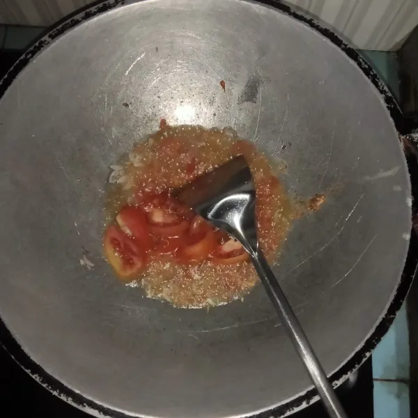 Tambahkan bumbu halus dan irisan tomat tumis sampai harum.