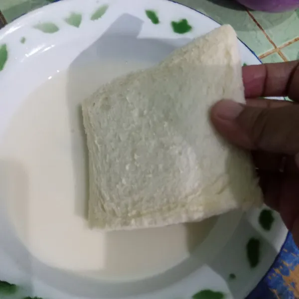 Celupkan roti tawar pada susu cair.