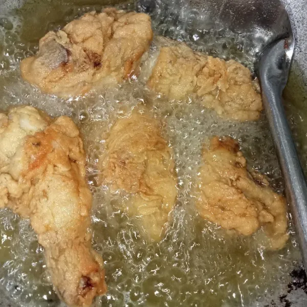Panaskan minyak lalu masukkan ayam, goreng ayam hingga kuning keemasan, angkat tiriskan dan sajikan.