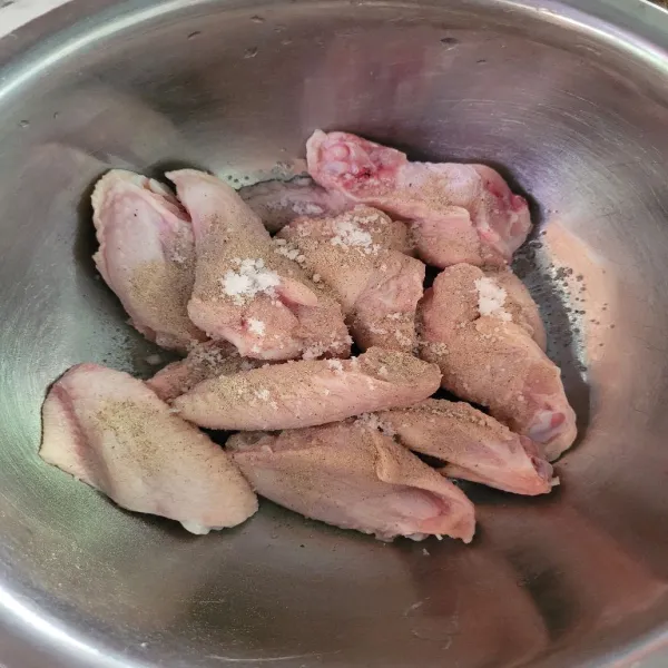 Potong sayap ayam, kemudian cuci bersih. Marinasi ayam dengan garam dan lada bubuk selama 30 menit