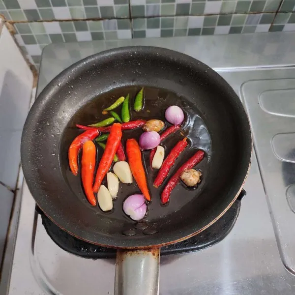 Goreng cabe merah, cabe rawit hijau, cabe rawit merah, kencur, bawang merah dan bawang putih hingga layu, kemudian tiriskan.