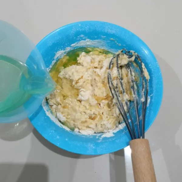 Kemudian tuang minyak sayur dan air. Aduk kembali hingga tercampur rata.