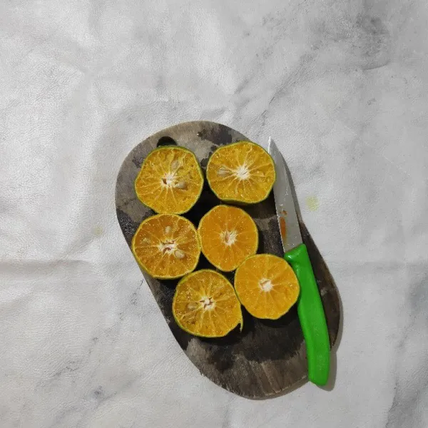 Cuci bersih jeruk lalu belah menjadi 2.