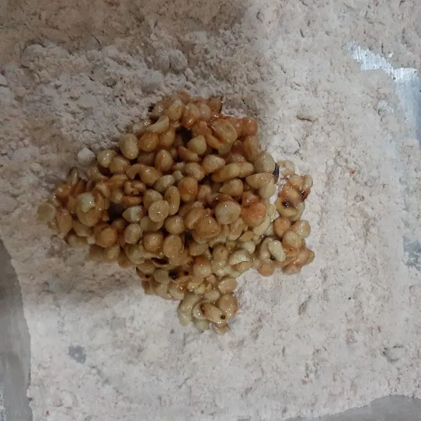 Letakkan kacang pada sisa bahan pembalur dan balur kacang dengan bantuan kedua tangan hingga terbalur dengan baik.