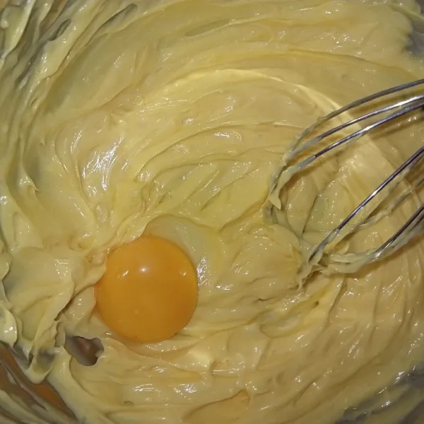 Kocok salted butter, margarin, dan gula halus dengan whisk hingga mengembang dua menit. Masukkan kuning telur aduk rata.