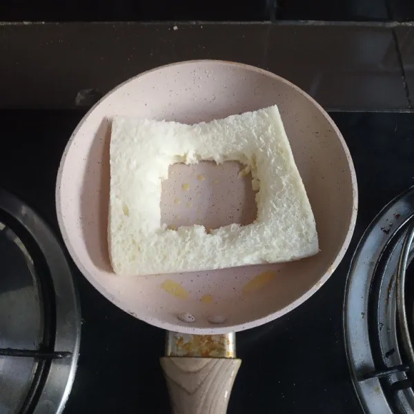 Iris bagian tengah tumpukan roti, panggang di atas teflon yang telah diolesi margarin.