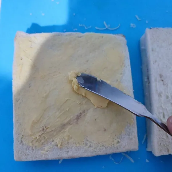 Tutup dengan roti tawar yang sudah dioles selai cokelat kacang. Kemudian oles sisi atas dengan margarin.