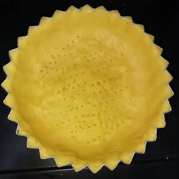 Pipihkan kulit pie di dalam cetakan yang sudah diolesi dengan margarin ratakan didalam cetakan, kemudian tusuk menggunakan garpu bagian dasarnya.