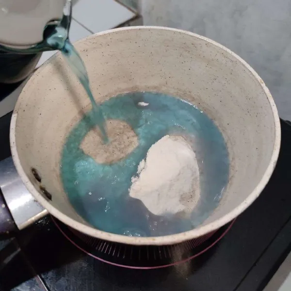 Masukkan agar-agar ke dalam milk pan kemudian tuang air telang. Aduk dengan whisk. Nyalakan apinya.