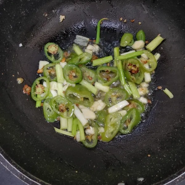Tumis bawang putih dan cabe gendot hingga harum dan layu. Kemudian masukkan daun bawang, aduk rata.