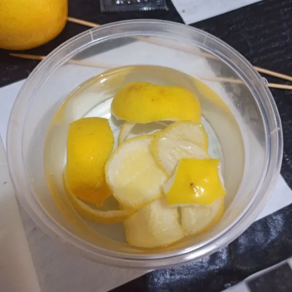 Bersihkan kulit lemon, lalu ambil airnya. Rendam di air panas selama 10 menit.