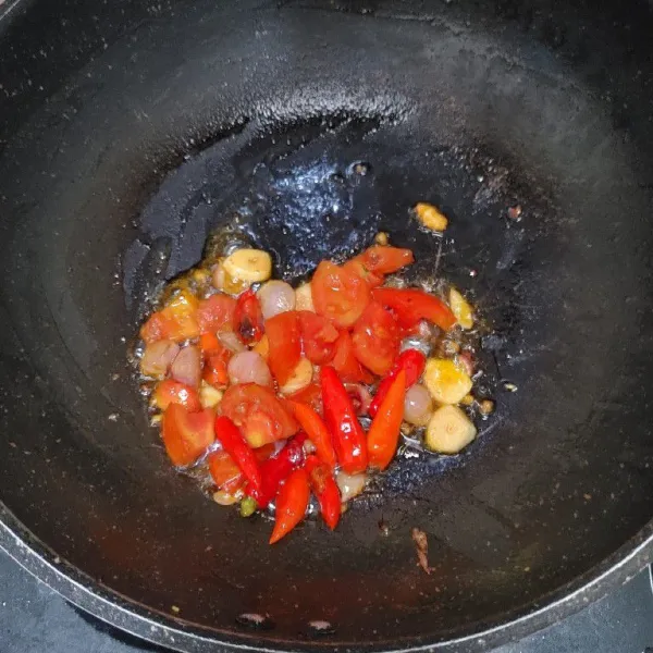 Goreng bahan sambel tomat, bawang merah, bawang putih dan cabe rawit sampai layu.