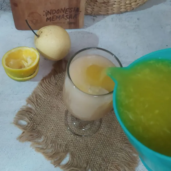 Tuang jus pear ke dalam gelas saji, lalu tuang air jeruk perasnya.
