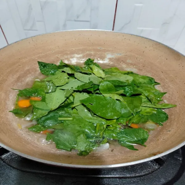 Tambahkan sayur katu, beri garam dan kaldu bubuk. Koreksi rasa