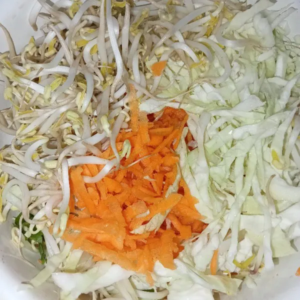 Masukkan wortel serut, kubis, dan tauge di dalam wadah.