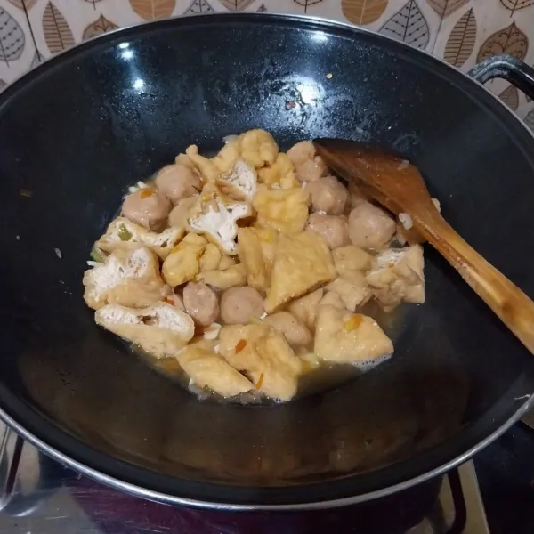 Tambahkan tahu, masak hingga kuah meresap tapi tidak sampai asat. Tambahkan minyak wijen. Aduk rata. Padamkan api. Sajikan.