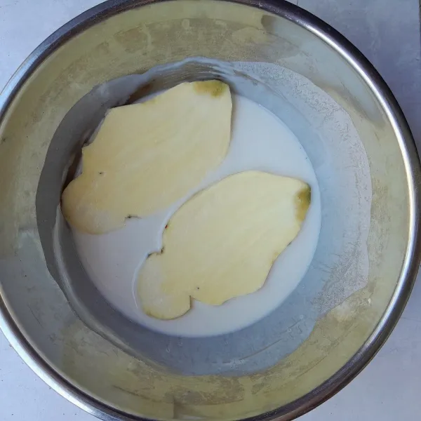 Masukkan ubi ke dalam wadah berisi adonan tepung. Balut ubi dengan adonan tepung hingga rata.