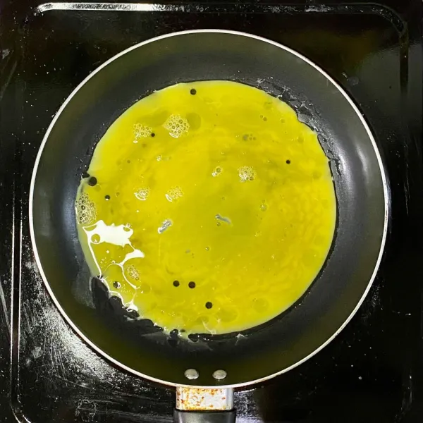 Kocok lepas telur dan tambahkan garam. Goreng telur hingga matang. Sajikan nasi goreng berselimut telur dadar.