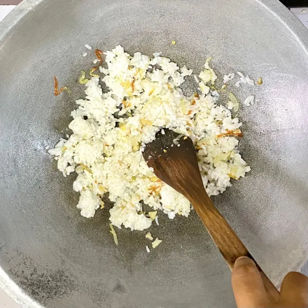 Tambahkan nasi, aduk dan masak hingga nasi agak kering.