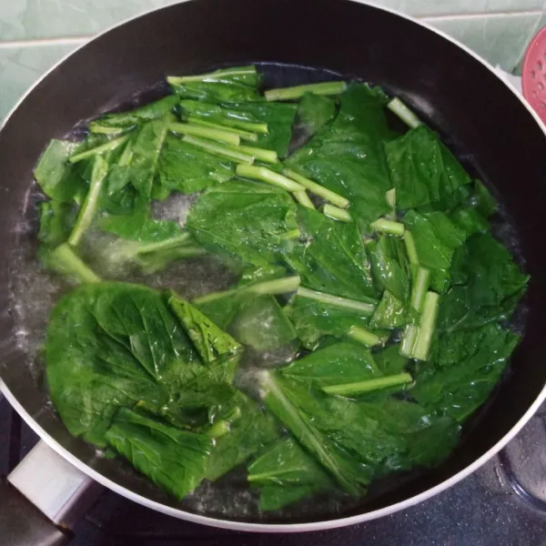 Didihkan air, rebus sawi tunggu ½ matang.