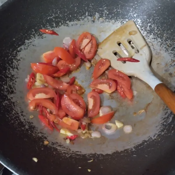 Masukkan cabai dan tomat, masak hingga tomat layu.