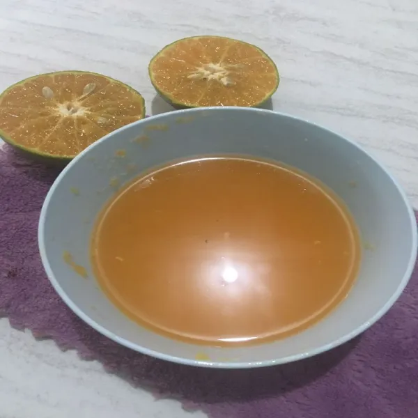 Belah jeruk kemudian peras, sisihkan airnya