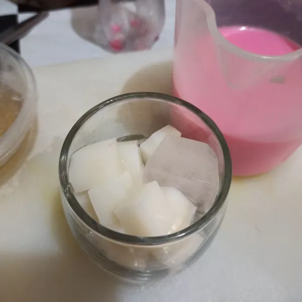 Tuang es batu dan jelly susu ke gelas.