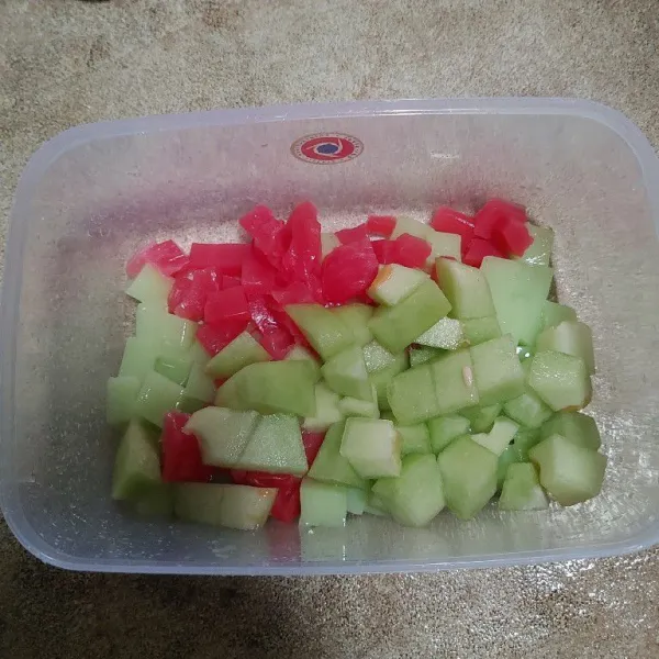 Campur jelly dan buah melon di dalam wadah.