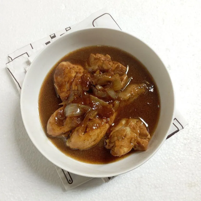 ibu rumah tangga sedang memasak ayam kecap di dapur