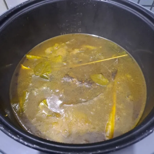 Nyalakan rice cooker, masak selama 1,5 jam. Buka perlahan, beri garam secukupnya saja karena bumbu instan sudah asin. Aduk rata, tutup kembali. Masak kembali selama 30 menit agar bumbu makin meresap dan daging empuk. Matikan rice cooker, rawon siap disajikan dengan tambahan taburan bawang merah goreng.