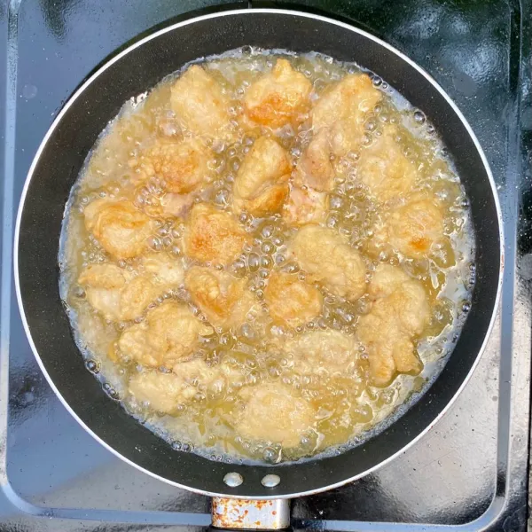Goreng ayam dengan minyak panas hingga matang.