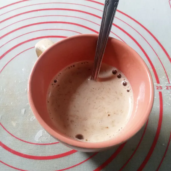 Dalam cangkir, masukkan bubuk kopi cappuccino dan chocolate granules. Tuang air panas, aduk sampai larut. Sisihkan sebentar.