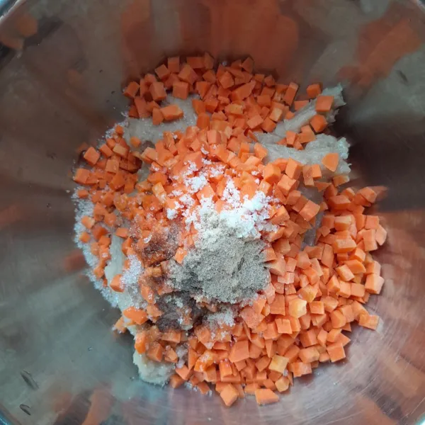 Masukkan potongan wortel, air es, garam, gula pasir, merica bubuk, minyak wijen, saus tiram, dan kecap ikan. Aduk menggunakan spatula hingga tercampur rata.