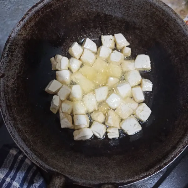 Taburi tahu dengan sedikit garam lalu goreng hingga berkulit.