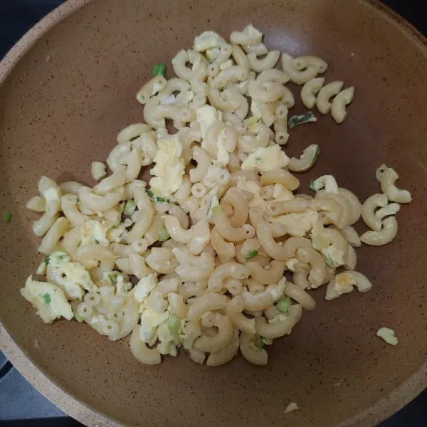 Tumis macaroni di dalam wajan dengan sedikit minyak, kemudian tuang kocokan telur. Aduk cepat.