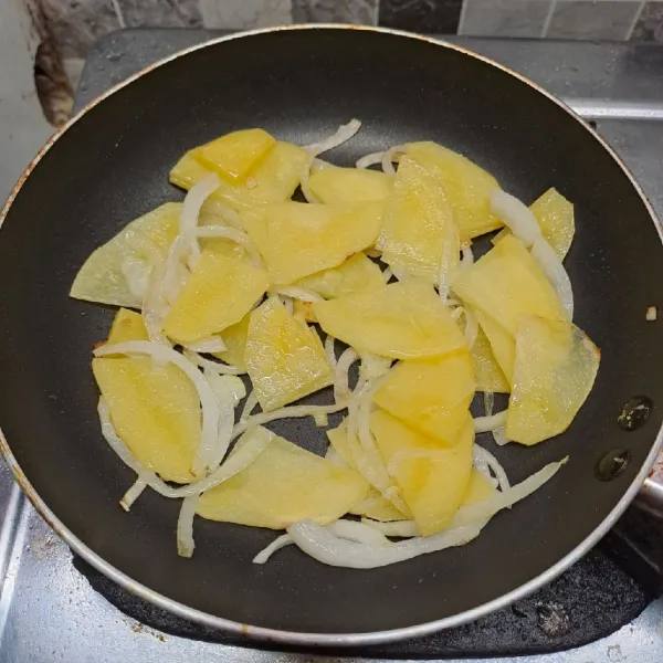 Tumis bawang bombay dan irisan kentang sampai harum dan kentang empuk. Angkat dan sisihkan.