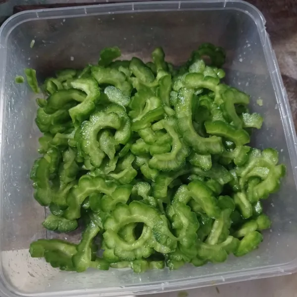 Belah dua pare, buang bagian bijinya. Lalu iris kecil-kecil, beri garam kemudian remas sampai layu. Cuci sampai benar-benar bersih dan tidak asin.