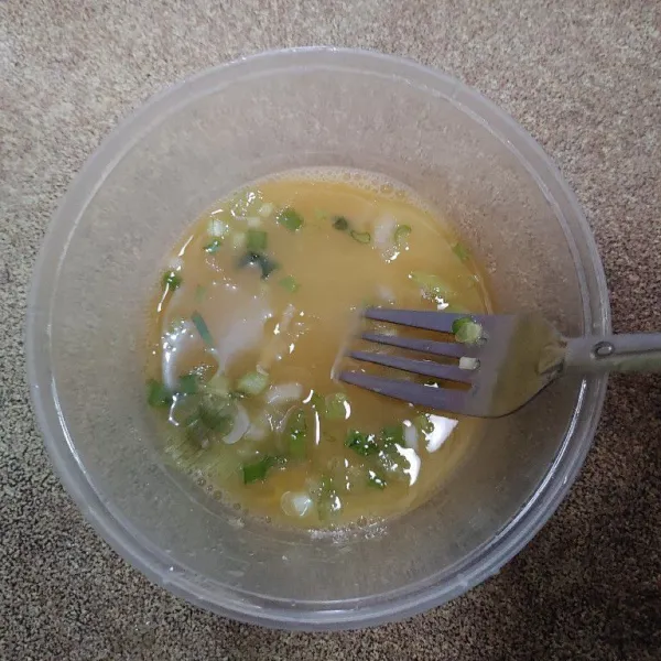Kemudian tambahkan irisan daun bawang, kocok lagi sampai rata.