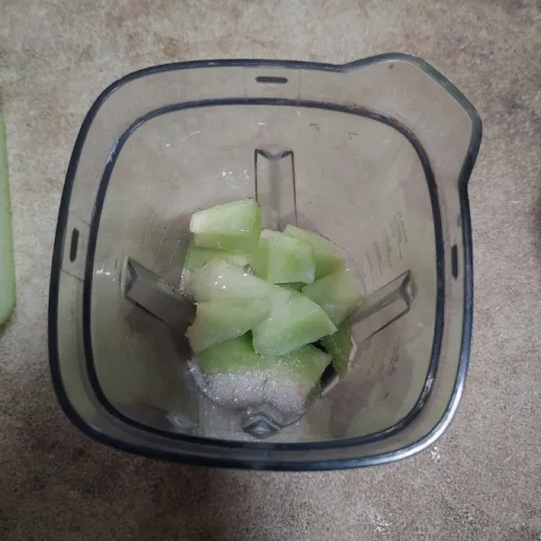 Masukkan potongan buah melon ke dalam blender, tambahkan gula pasir dan krimer kental manis.