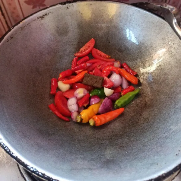 Goreng bahan sambal, cabai rawit, cabai merah keriting, bawang merah, bawang putih, tomat merah dan terasi hingga matang.