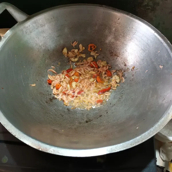 Panaskan minyak, tumis bawang putih sampai harum lalu masukan cabe dan udang rebon yang sudah dicuci bersih. Aduk-aduk sampai agak kering.