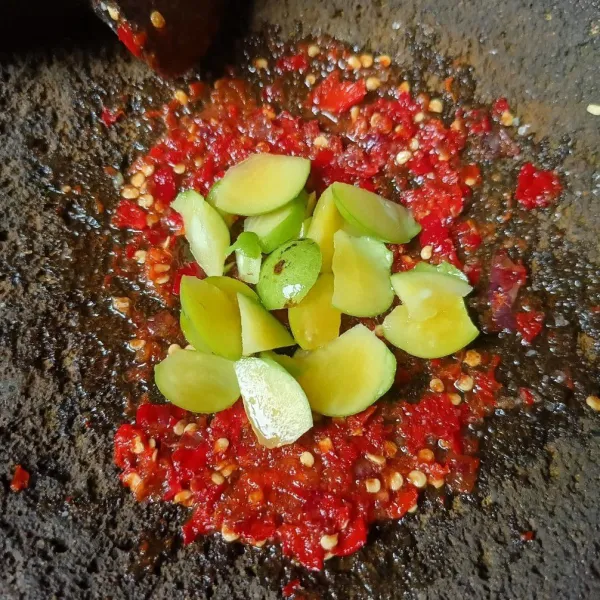 Masukkan irisan buah gandaria dan ulek lagi sampai hancur.