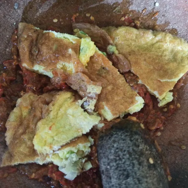 Tambahkan telur dadar yang sudah dipotong-potong, penyet-penyet menggunakan ulekan, sajikan dengan nasi hangat.