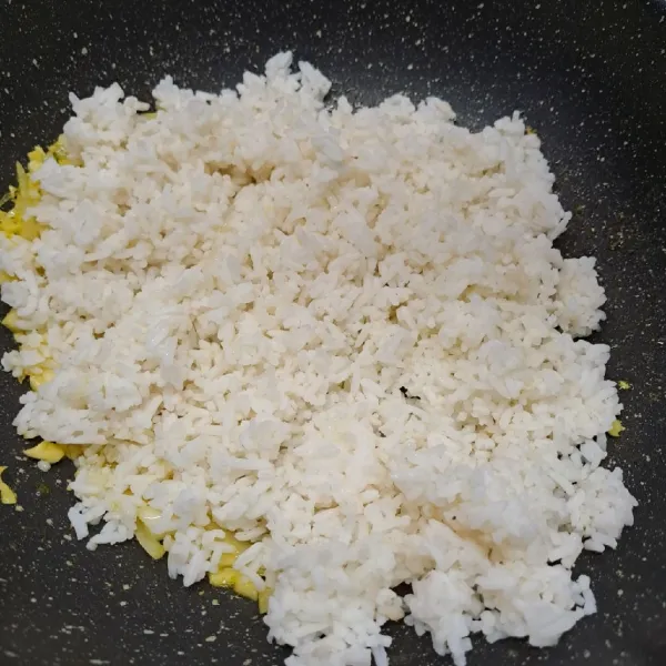 Masukkan nasi putih, aduk rata dengan tumisan.