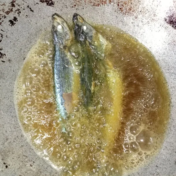 Panaskan minyak secukupnya lalu masukkan ikan goreng ikan hingga setengah matang.