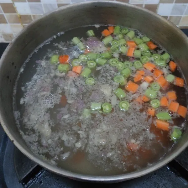 Didihkan air, masukkan bumbu halus, wortel, buncis dan kentang. Masak sampai sayuran matang.