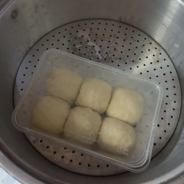 Lalu tutup dengan tutup thinwall dan tunggu mengembang 2 kali sekitar 30-60 menit sesuai suhu udara masing-masing. Semakin panas biasanya mengembangnya semakin cepat. Kemudian buka tutup thinwall dan letakkan di atas kukusan yang sudah dipanaskan.