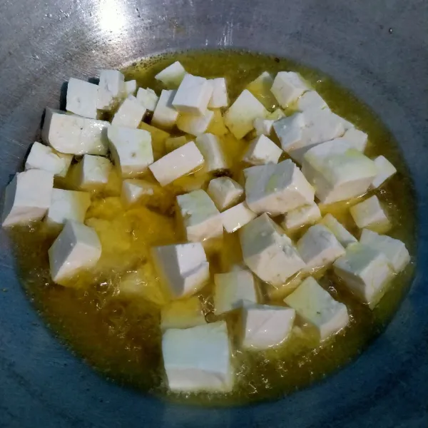 Panaskan minyak goreng tahu hingga setengah matang