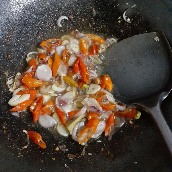 Panaskan minyak sayur dengan api sedang dan tumis bawang merah, bawang putih, cabe rawit hingga layu.